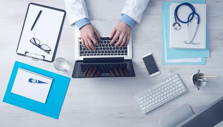 doctor typing on computer